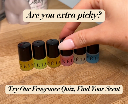 Set of NÉIA fragrance bottles on a wooden surface with text overlay.