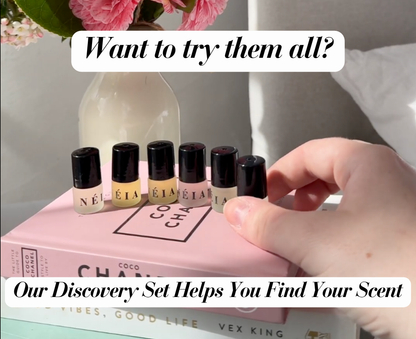 Set of small bottles with black caps on a pink book, with text promoting a discovery set.