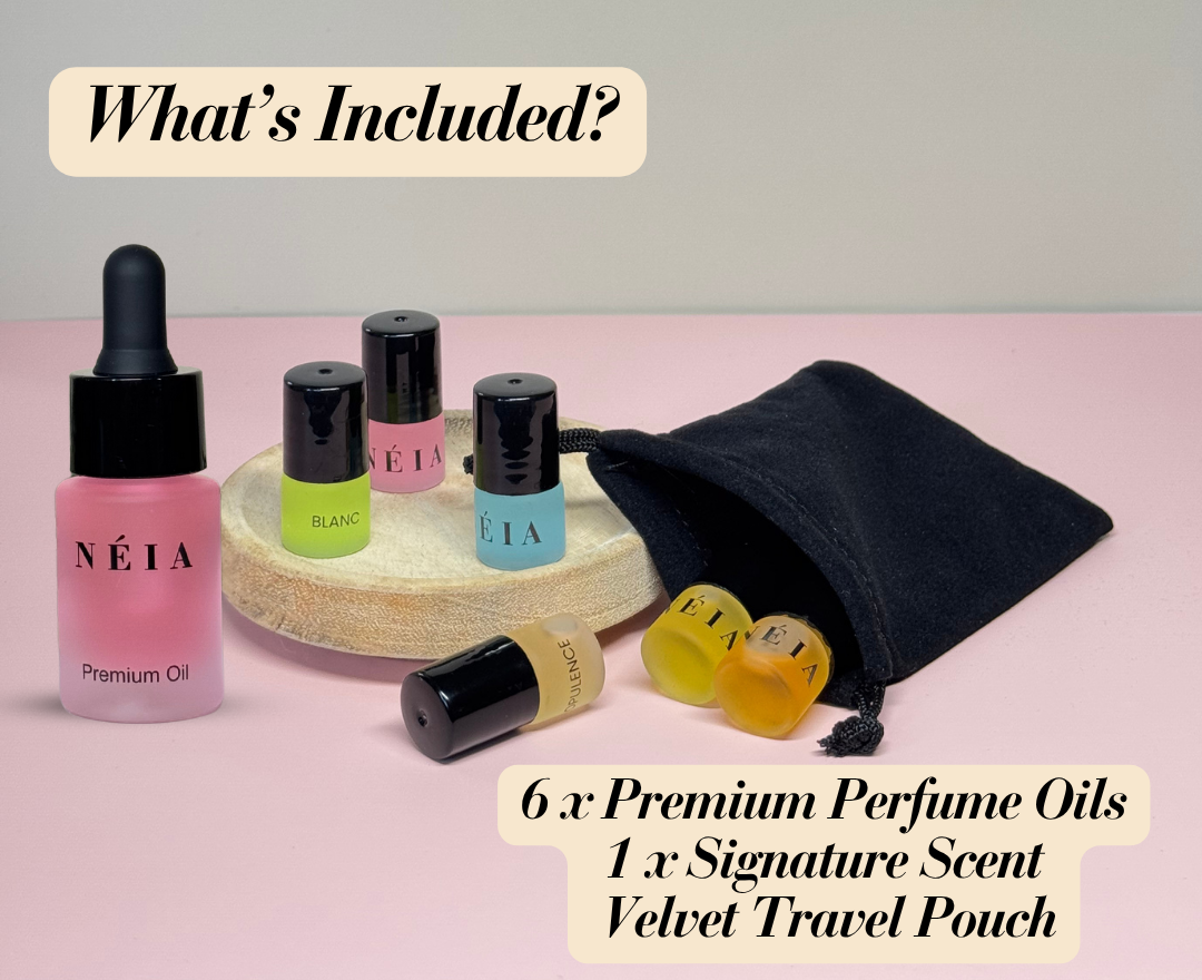 Collection of NÉIA premium perfume oils and a velvet travel pouch on a pink background.
