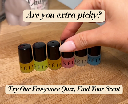 Set of small perfume bottles with black caps on a wooden surface, promotional text overlay.