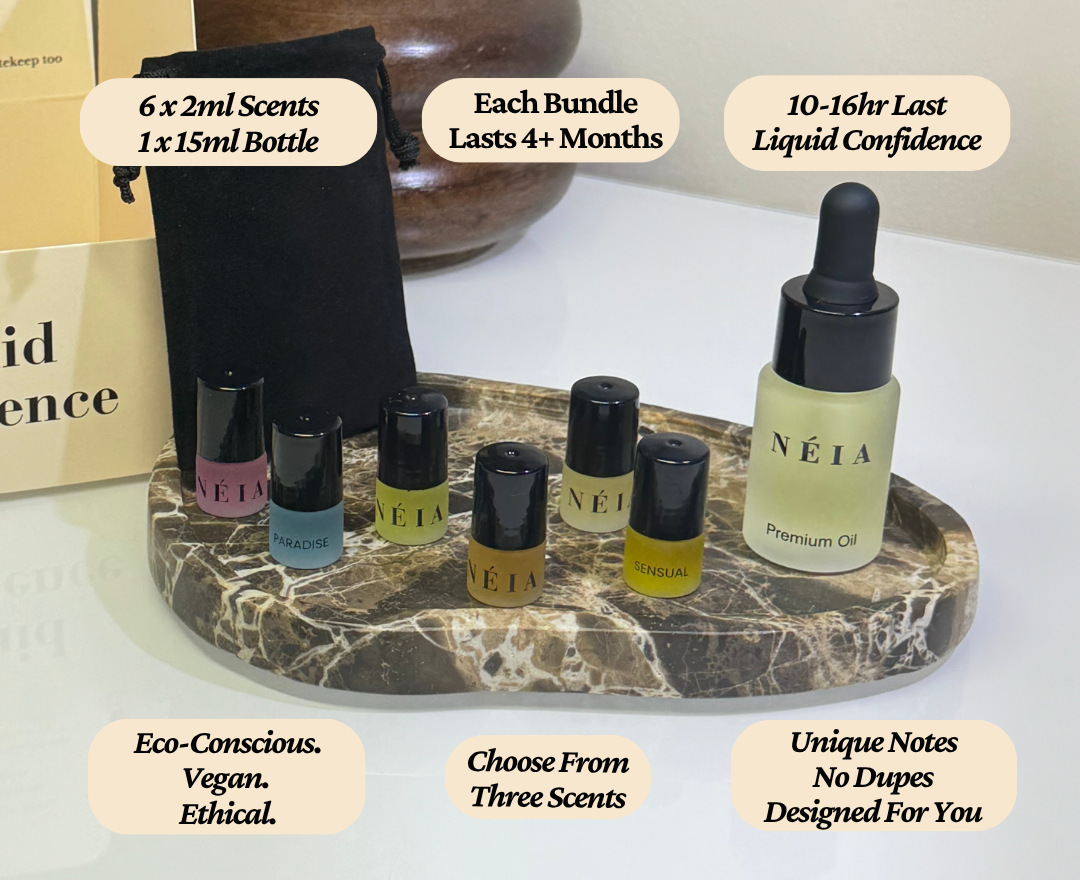 NÉIA premium perfume oil set with bottles and a dropper on a marble tray.
