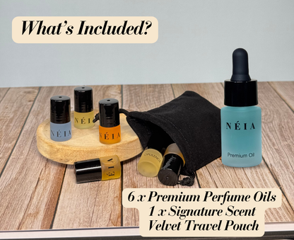 Collection of NÉIA perfume oils and a travel pouch on a wooden surface.