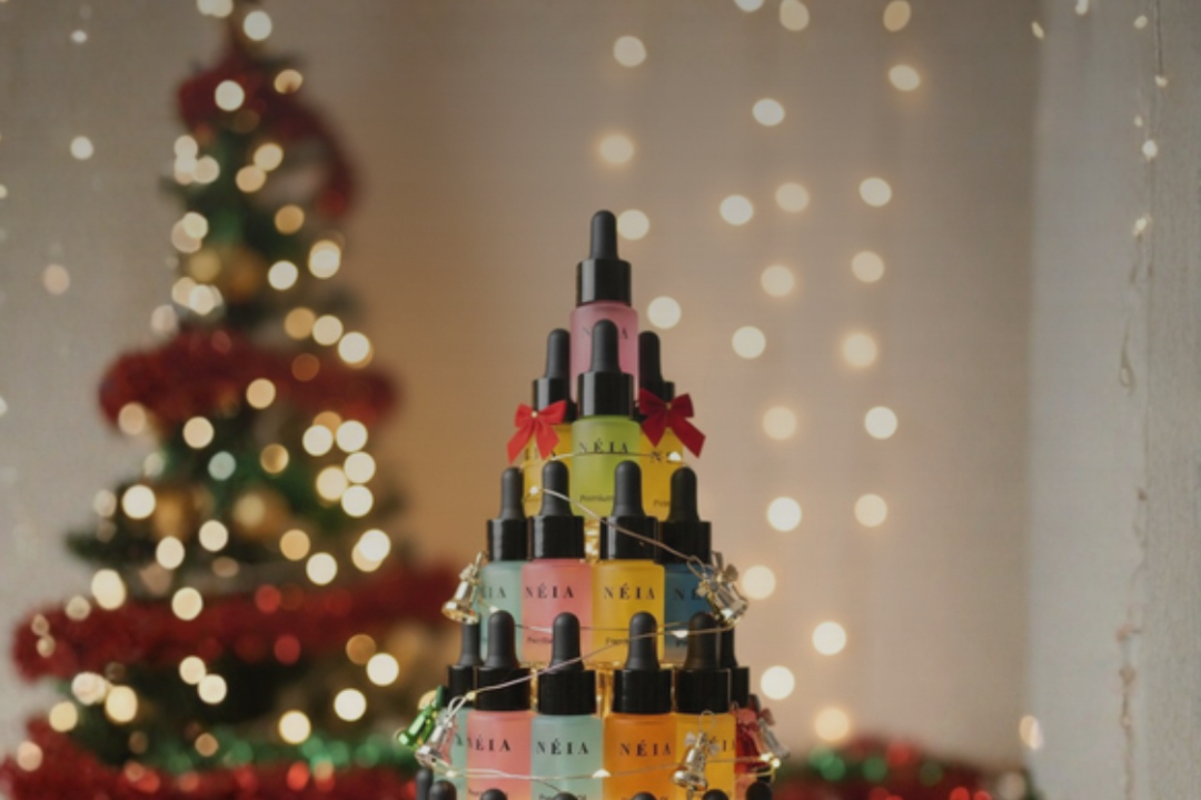 Stack of small bottles with colorful labels arranged in a Christmas tree shape against a festive background.